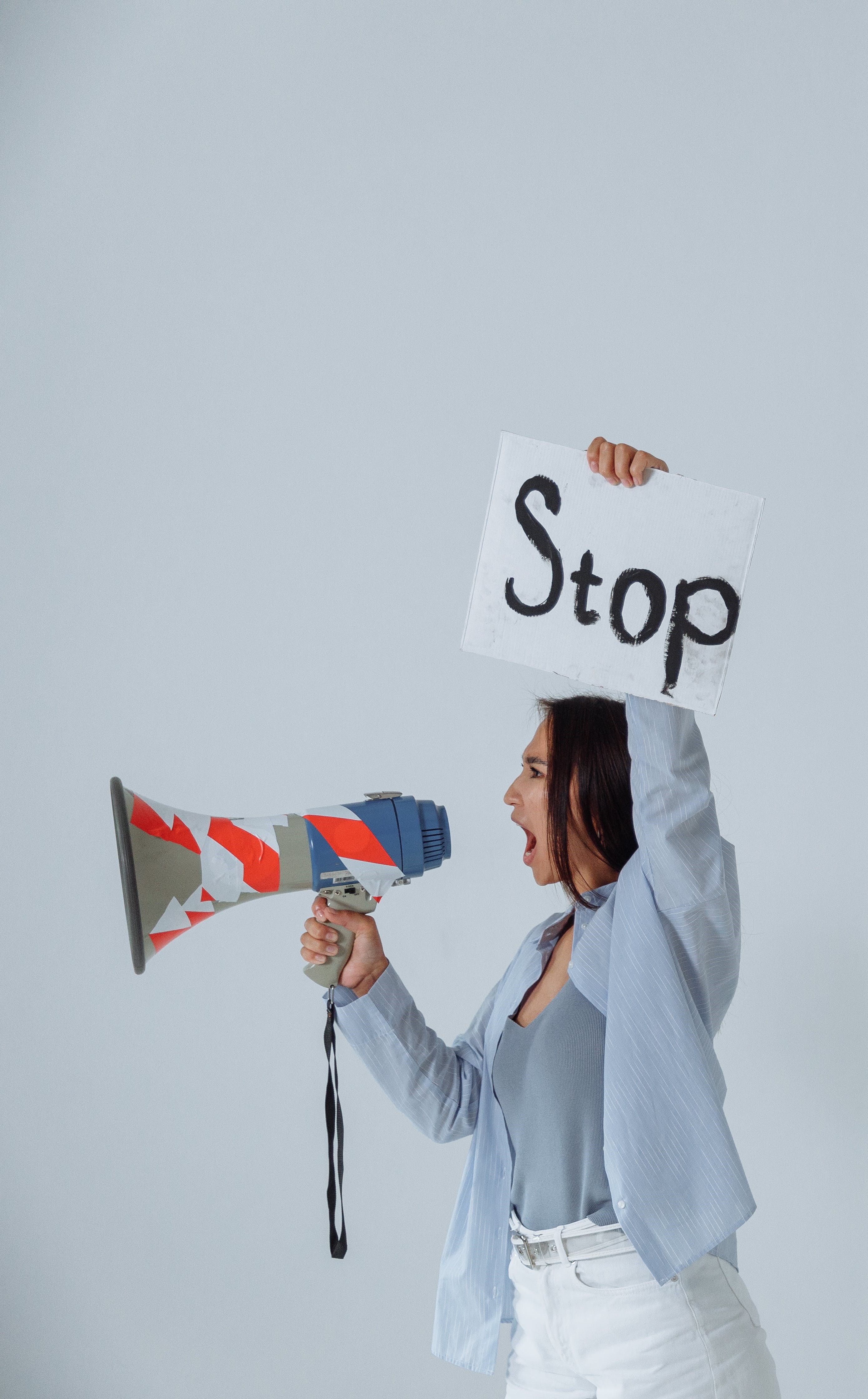 A woman holding a stop sign with a megaphone, ensuring clear communication and control in a busy environment.
