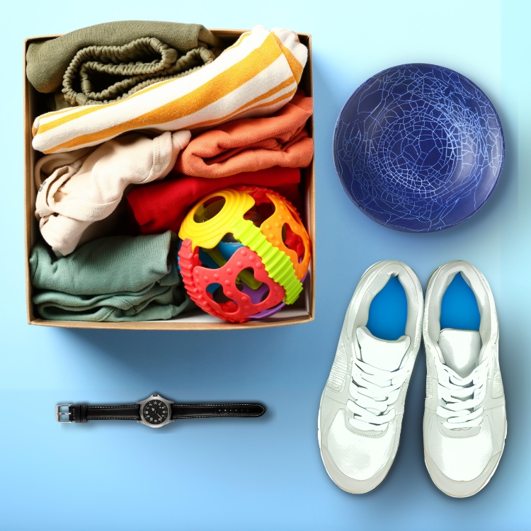 A box with clothes, a blue bowl, a pair of trainers and a watch.