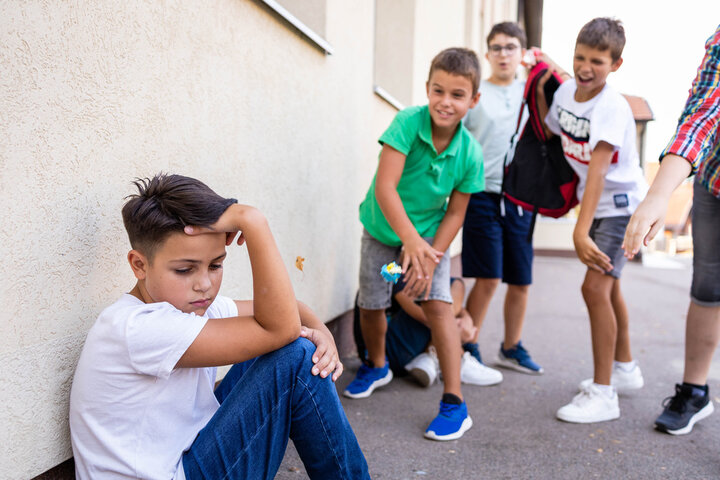 A child being bullied, symbolizing an Autistic child experiencing social isolation at school. A child being bullied, symbolizing an Autistic child experiencing social isolation at school.