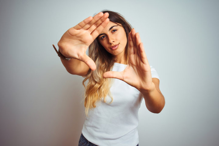 Woman peering through a frame made by her hands and fingers, symbolizing a new perspective for understanding autism. Woman peering through a frame made by her hands and fingers, symbolizing a new perspective for understanding autism.