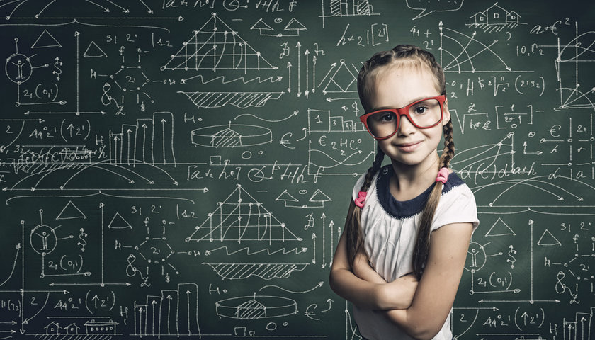 Confident young girl in red glasses standing in front of chalkboard covered in math and science formulas, symbolizing hidden intelligence and savant potential in severe autism. Confident young girl in red glasses standing in front of chalkboard covered in math and science formulas, symbolizing hidden intelligence and savant potential in severe autism.