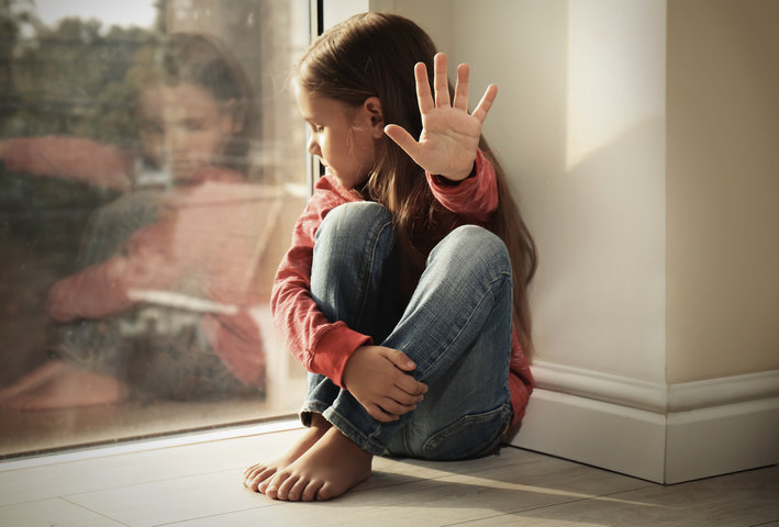 Young girl sitting on the floor by a window with hand raised in refusal, symbolizing emotional overload, sensory withdrawal, and the misunderstood sensitivity in severe autism. Young girl sitting on the floor by a window with hand raised in refusal, symbolizing emotional overload, sensory withdrawal, and the misunderstood sensitivity in severe autism.