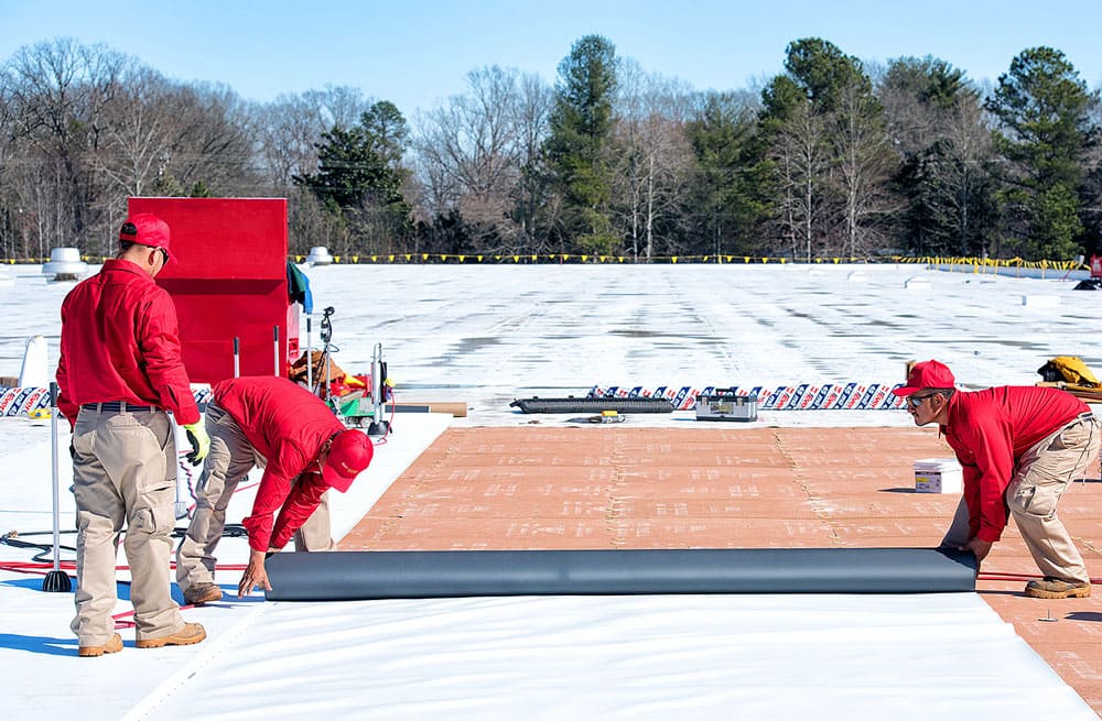 Roofing Crew Installing a new roof on a commercial building Roofing Crew Installing a new roof on a commercial building