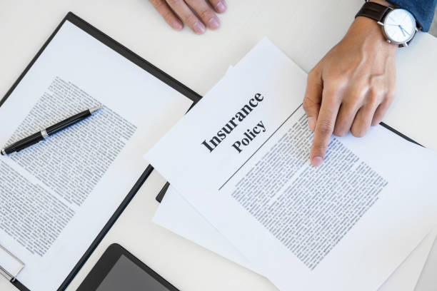 A pile of legal policy documents representing insurance policies.