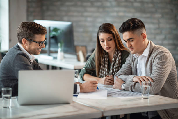 Insurance agent consulting with a client in an office - Top qualifications for success in the insurance industry