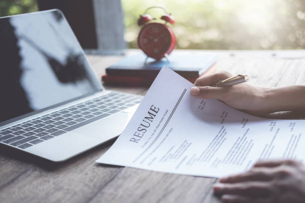Person editing resume surrounded by interview related items