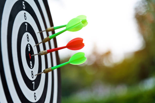 A target with a bulls-eye in the middle and darts surrounding it.