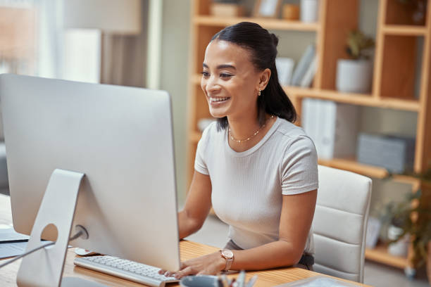 A person smiling while working on a computer.