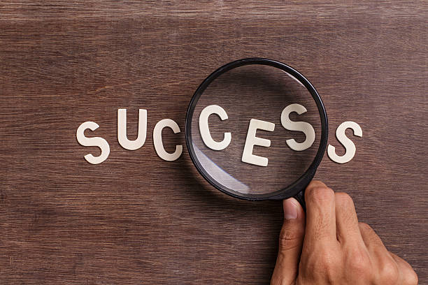 Magnified image of the word "SUCCESS" on a blank background.
