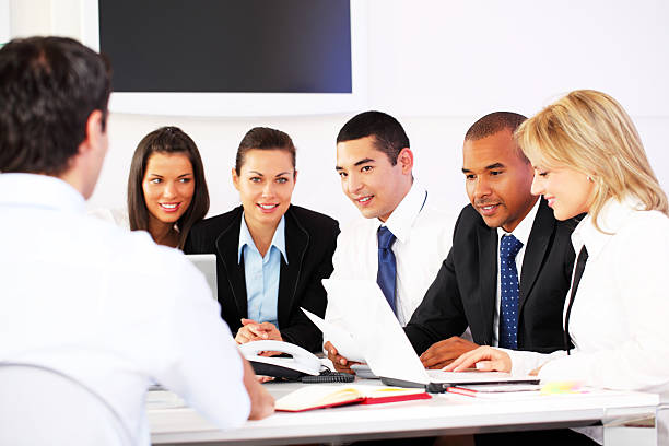 A diverse group of insurance agents collaborating in a modern office, discussing digital technology and job opportunities in the life insurance industry.