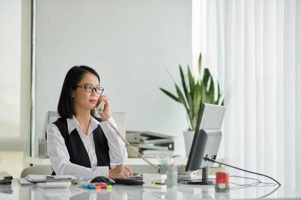 Insurance agent working at desk, communicating with client.