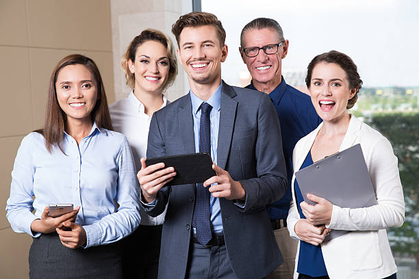 Group of diverse individuals holding insurance-related objects, representing breaking specialization in independent insurance agent jobs
