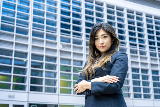 A confident salesperson holding a tablet device and engaging with a potential client in front of a modern city skyline.
