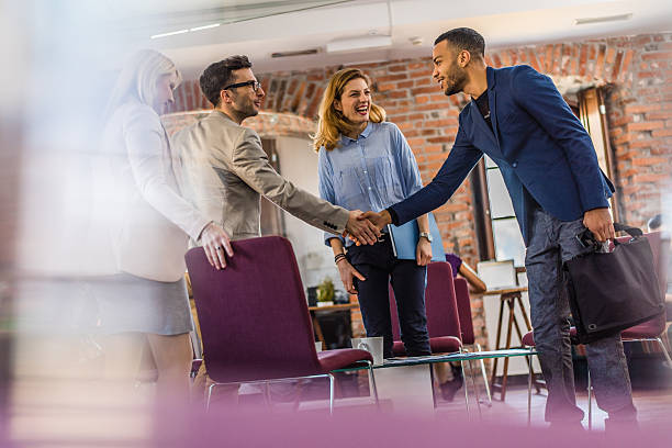 Two insurance agents shaking hands and discussing insurance policies
