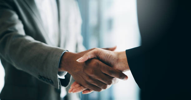 Two businesspeople shaking hands in agreement symbolize the collaboration between our network of insurance companies and potential hires.