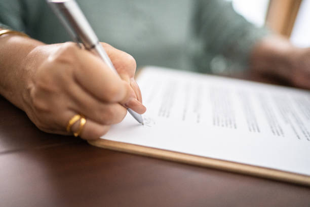 Image of a certificate and a hand holding a pen.