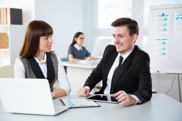 Insurance agent consulting with a client in a modern office, discussing life and health insurance responsibilities.