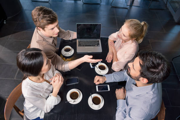 Insurance agents networking and discussing new clients over coffee.