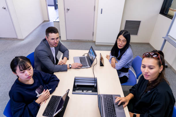 A diverse group of professionals in a modern office setting engaged in insurance jobs: discussing documents, making phone calls, and using laptops.
