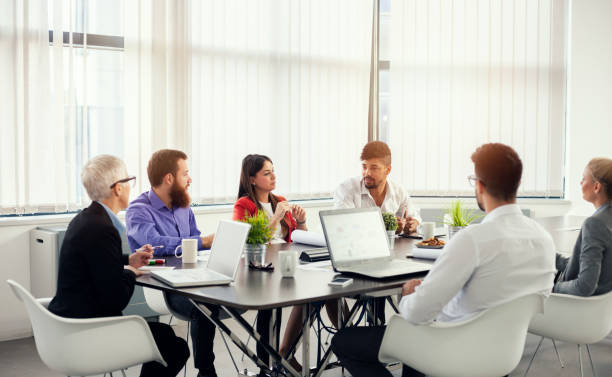  Picture of a diverse group of professionals having a team meeting: discussing papers and working collectively.