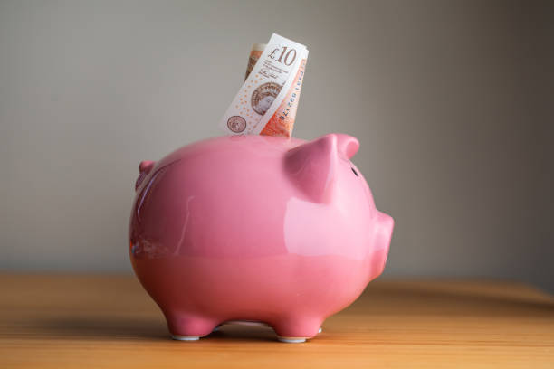  Image of a piggy bank overflowing with coins and money.