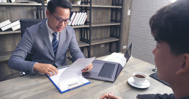  A confident insurance agent discussing insurance options with a client in a modern office setting.
