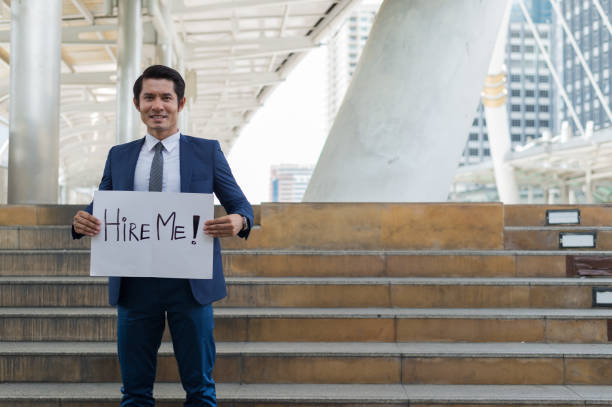 A job seeker standing in front of an office with a sign that says, "Career Opportunities"