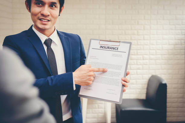 Insurance agent with clipboard in front of office building, representing professionalism and expertise in insurance certification.