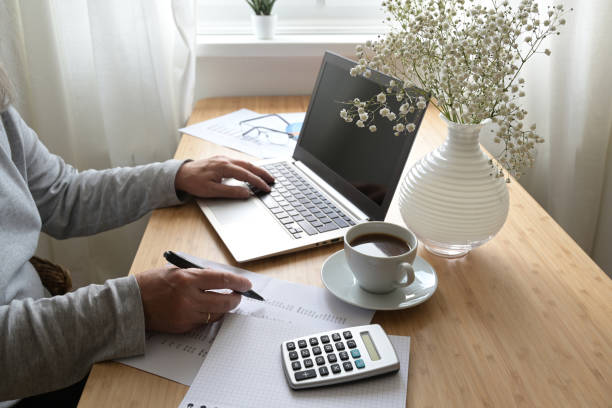 A well-organized home office with a laptop, notebook, pen, and a cup of coffee, representing the work from home opportunities for life and health insurance agents in 2023.