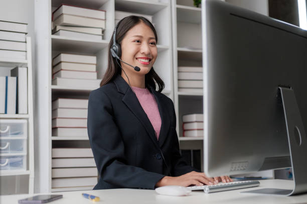"A remote insurance agent working professionally, speaking to a customer on a call while using a laptop and wearing a headset."