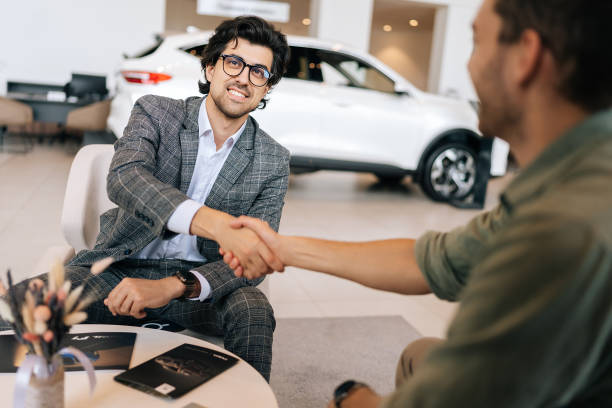 Licensed insurance agent shaking hands with a happy customer after finalizing a sale.