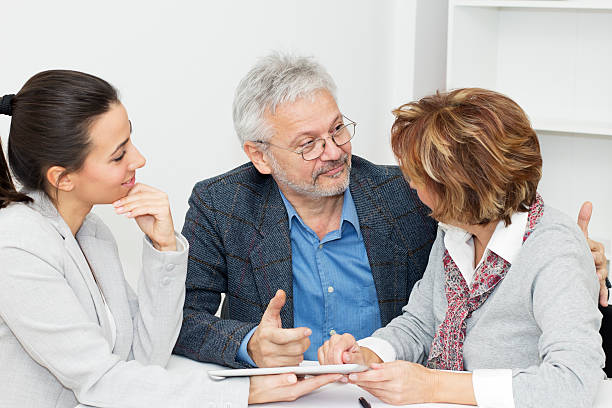  male insurance agent explaining health insurance plan to couple