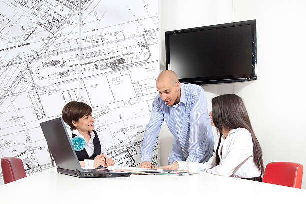 Successful life insurance agent explaining insurance policies to clients on a whiteboard.