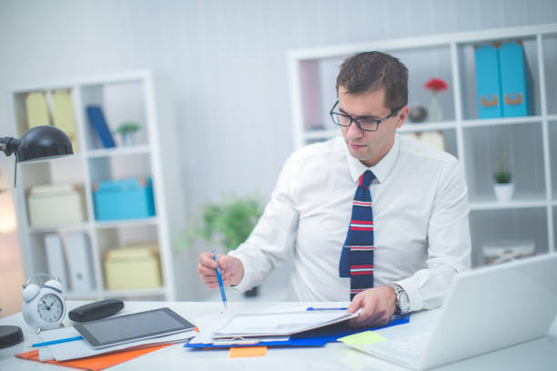 A life insurance agent's office set up - flat white desk with documents, laptop and headset