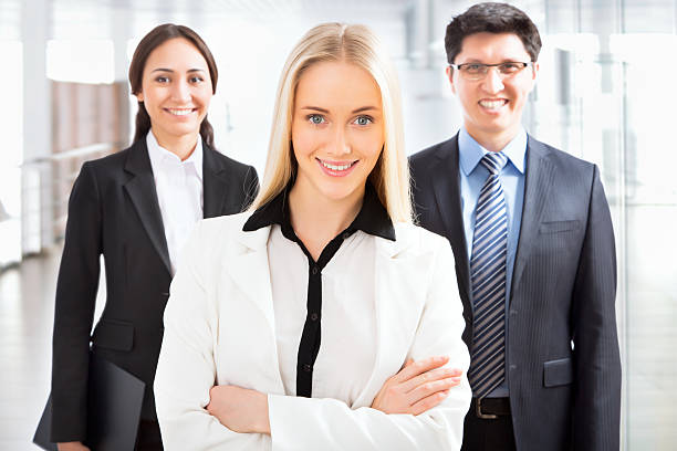 A team of five insurance agents with speakers in the background.