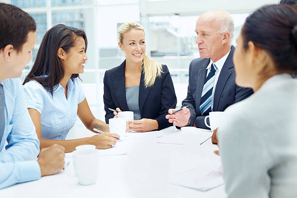 A diverse group of insurance agents discussing sales strategies in a modern office setting.