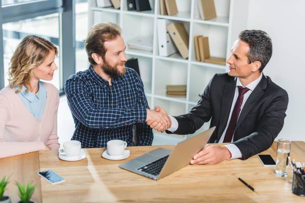 Two insurance agents shaking hands with a guy