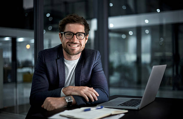 Happy young insurance agent working from home on a computer.