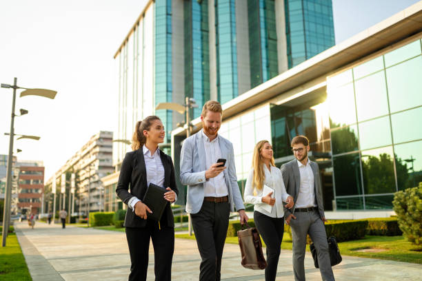 A growing team of successful insurance agents leaving their workplace with triumph.