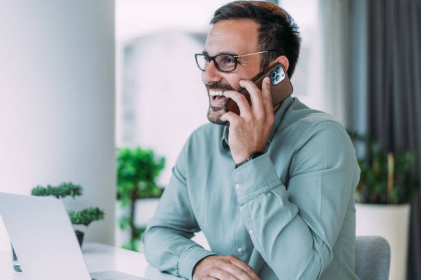 Insurance agent sitting at desk talking on phone.