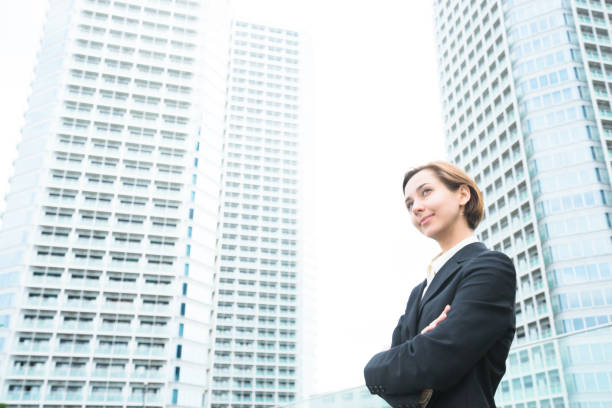 A successful life insurance agent holding a graph on a tablet, standing against a city skyline backdrop