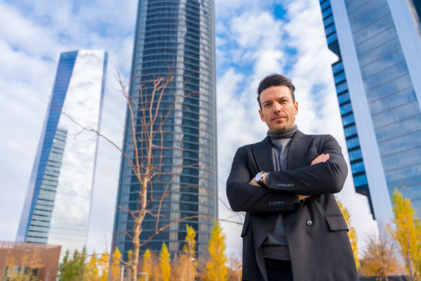 "A life insurance agent in professional attire, standing against a city skyline background, engaging with a client and holding a clipboard, representing the potential and professionalism of life insurance agents."