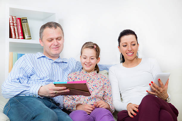 Family happily sitting on a couch with their life insurance policy binder.