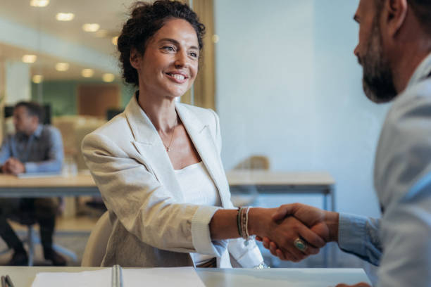 Professional man and woman shaking hands at Elite Life Agency.