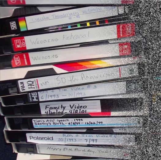 A stack of VHS home movies in a neat pile.