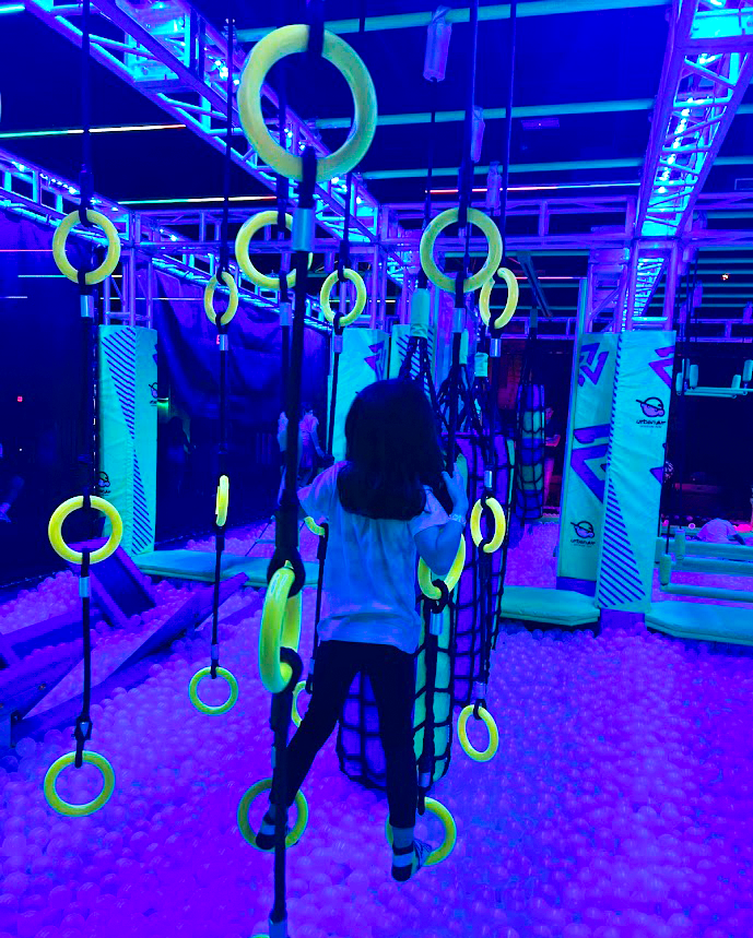 A girl playing in a rope course at Urban Air A girl playing in a rope course at Urban Air