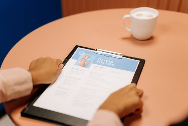 Woman's hands holding a resume Woman's hands holding a resume