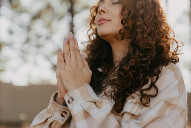 Woman with eyes closed and hands together Woman with eyes closed and hands together