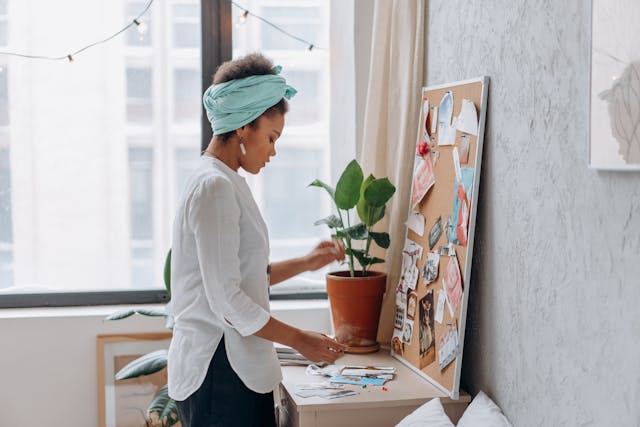 Woman pinning images on her corkboard Woman pinning images on her corkboard