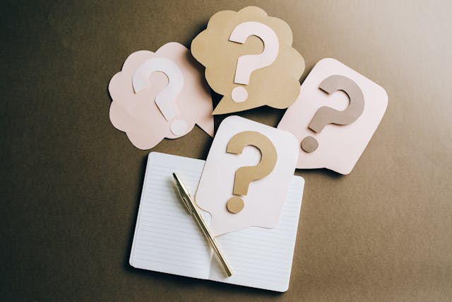 Question marks made of craft paper on a notebook Question marks made of craft paper on a notebook